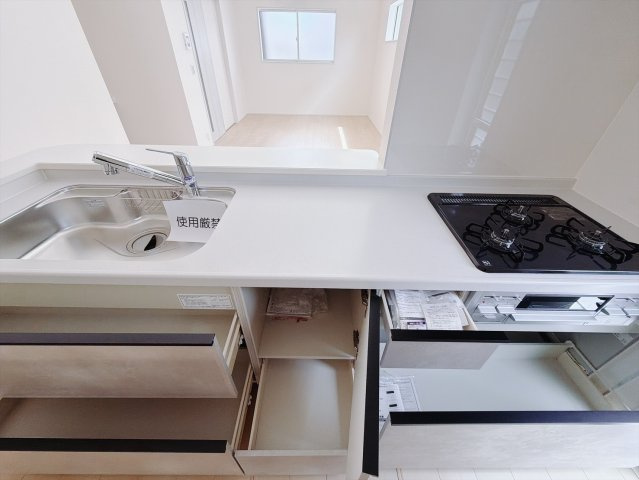 【新築戸建】藤岡市藤岡第13のキッチン|■キッチン｜ワークトップ下には、圧力鍋やパスタ鍋などのかさばる調理器具もラクラク収納可能なスライド収納！ものが溢れがちなキッチン回りもスッキリきれいに管理ができます♪