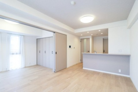 プラハ横浜センター南ステーションアリーナの居間・リビング|施工事例：キッチンとリビングが緩やかにつながる一体感のあるLDK。淡い木目のフローリングと白を基調にした内装が、明るく開放的な住空間を演出しています。