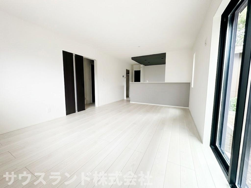 八王子市四谷町2期　の居間・リビング|白を基調とした内装にダークカラーの建具がアクセントになった、モダンなリビングダイニングです！大きな窓からたっぷりと自然光が入り、日中は明るく開放的な大空間でご家族みんなでゆったりとくつろげます。