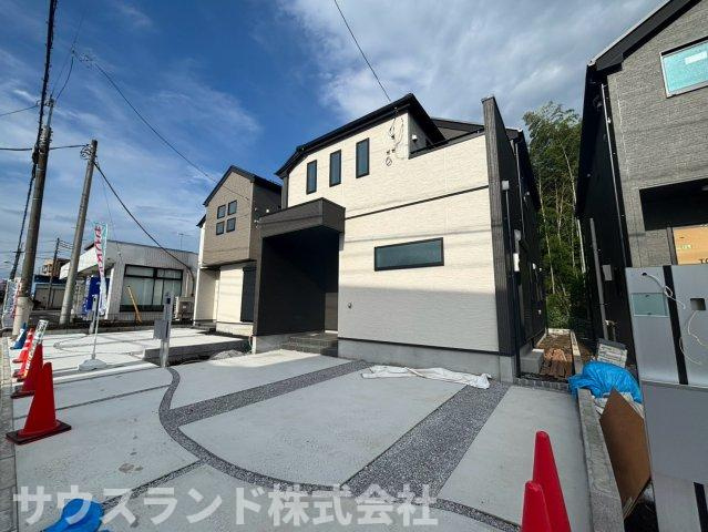八王子市四谷町2期の外観|少し離れた位置から見た外観写真です。建物の立体感や窓の配置をご確認いただけます。手前には広い駐車スペースがあり、車を2台並べて停めても余裕がございます。青空に映える明るい住まいです！
