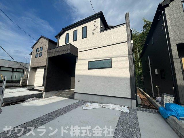 八王子市四谷町2期の外観|完成した建物の外観写真です。明るい白い外壁が青空に映える、モダンで清潔感のあるデザインです。手前にはコンクリート舗装された駐車スペースがあり、日々の車の出し入れもスムーズに行えます！
