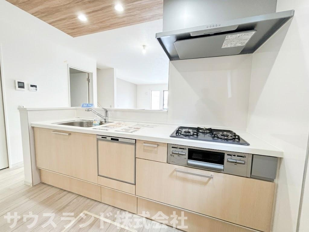 八王子市子安町4期のキッチン|作業スペースが広く取られた、使い勝手の良いシステムキッチンです！３口コンロでお料理の同時進行もしやすく、忙しい時間帯の家事もスムーズに行えます。収納も豊富で、調理器具や食器類もすっきりと片付きます。