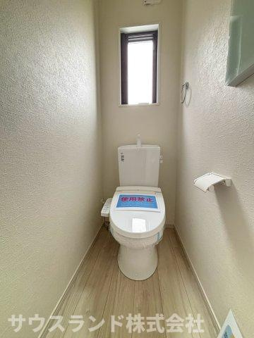 八王子市子安町4期のトイレ|窓があり明るく清潔感あふれるトイレです！快適にお使いいただける温水洗浄便座がしっかりと完備されています。手すり付きのペーパーホルダーも設置されており、どなたでも使いやすいバリアフリーな設計です。