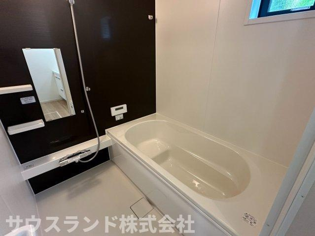八王子市北野台35期の浴室|ダークブラウンのパネルが落ち着いた雰囲気を演出する広々としたバスルームです！足を伸ばしてゆったりと浸れる大きな浴槽で、毎日の疲れをしっかりと癒やせます。窓付きで換気しやすくカビ対策も簡単に行えます。