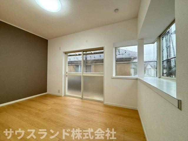 八王子市下恩方町の洋室|二面に窓があり明るい光が差し込む、風通しの良い洋室です。落ち着いた色のアクセントクロスが、空間をグッとおしゃれに見せてくれます。出窓のスペースに家族の写真や小物を飾って、お気に入りの空間にできます。