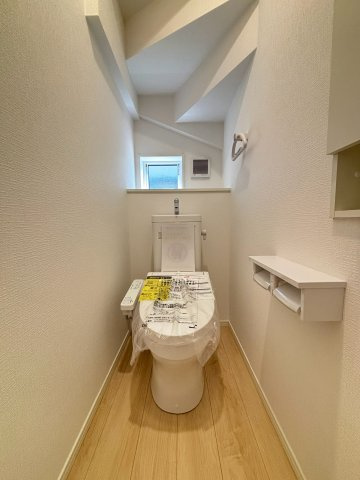 八王子市泉町　17号棟のトイレ|小窓から優しく自然光が差し込む、明るく清潔感のあるトイレ空間です。ペーパーのストックやお気に入りの小物を置いておける便利な棚も備わっています。お手入れがしやすい素材で、毎日のお掃除もラクラクです。