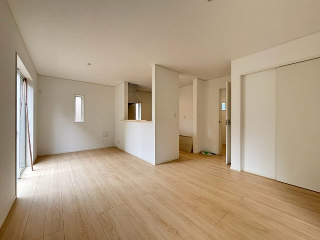 八王子市泉町　17号棟の居間・リビング|広々としたフローリングが広がる、開放感のあるリビングです。大きめのソファやテレビを置いてもゆとりがあり、ご家族みんなでゆったりとくつろげます。休日はのんびりと映画鑑賞などを楽しむことができます。