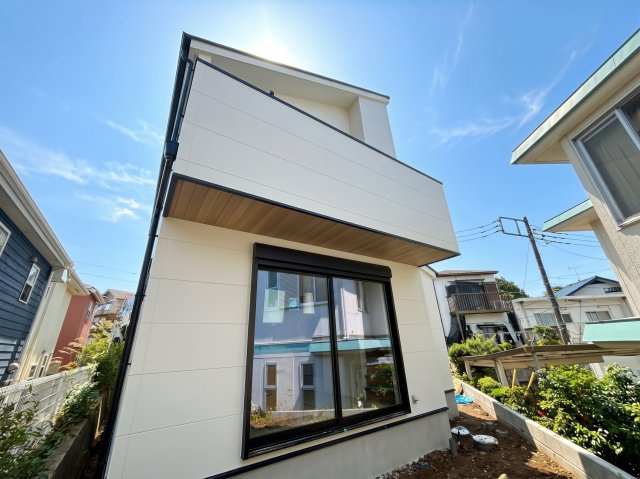 武蔵村山市神明　1棟現場の外観|道路から少し上がった敷地になっており、通行人の視線が気になりにくくプライバシーがしっかりと守られます。玄関先には植栽スペースも設けられ、季節のお花を植えてご近所さんとの会話も弾みそうですね。
