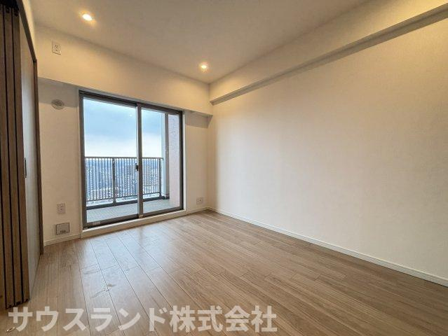 マクシスタワーズアーバンデュオの洋室|大きな窓から光を取り込む、明るく伸びやかな洋室。バルコニーへ直接出られるため、換気や洗濯物の取り込みもしやすい配置です。明るい木目の床が室内になじみ、家具も合わせやすい内装空間です。