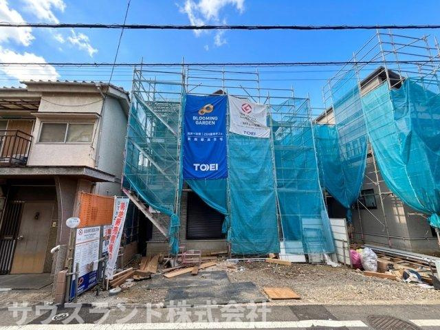 八王子市万町　1号棟の外観|異なる角度から見た建築中の外観写真です！前面の道路はゆとりがあり、大きめのお車でもスムーズに出し入れできる環境が整っています。周辺は落ち着いた住宅街で、完成後も穏やかな毎日をお過ごしいただけます。