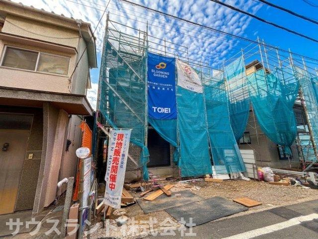 八王子市万町　1号棟の外観|道路側からしっかりと確認できる建築中の現地の様子です！隣り合う建物との間隔にゆとりがあり、各お部屋への風通しや採光の良さがうかがえます。安全に配慮された丁寧な施工で、マイホームの完成が待ち遠しいです。