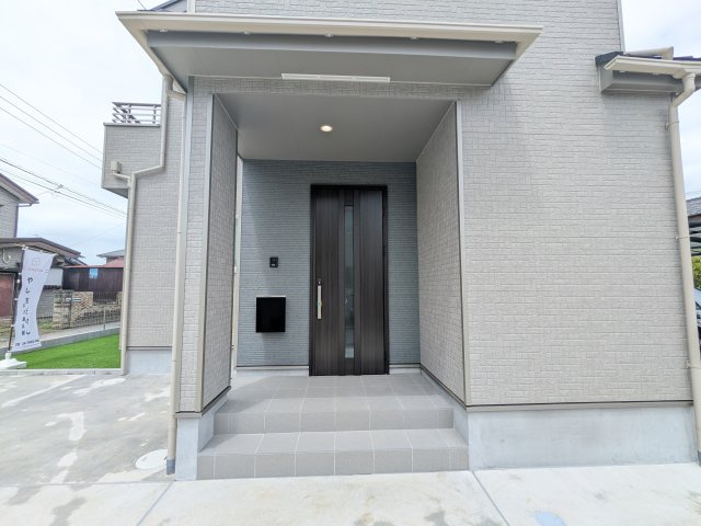 阿見町うずら野2丁目15番　新築戸建て　A号棟の玄関|お洒落な玄関ドアと洗練された外壁デザイン。家の顔にふさわしい上質な佇まいで、ご家族やお客様を迎えます。