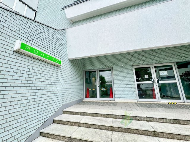 戸山ハイツ27号棟のエントランス|エントランスや駐車場、ちょっとしたお庭部分のお手入れが行き届いていてとてもキレイでした。資産価値を高める部分としては重要なことです。
