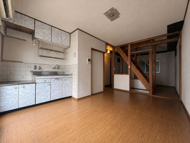 東住吉区住道矢田８丁目の居間・リビング|キッチンと居室がつながる使いやすいLDK。木目調の床と階段まわりの造作が、あたたかみのある室内を演出