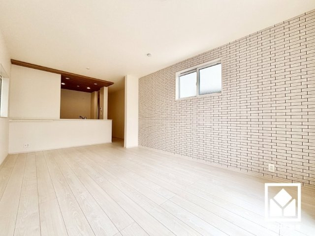尼崎市神田中通８丁目１期の居間・リビング|上品なホワイトブリック調のアクセントクロスが洗練された空間を演出。心地よい空間が広がるリビングで、家族みんなが快適に過ごせる時間を提供。