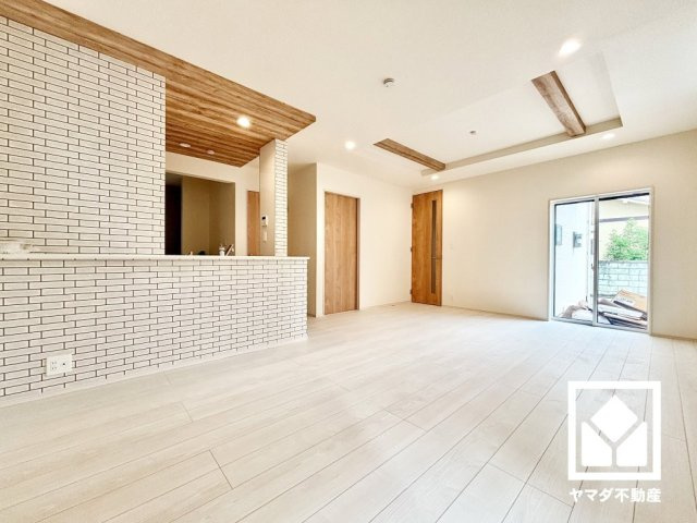伊丹市松ケ丘１丁目２期の居間・リビング|広々18.93帖のLDKが魅力。カフェライクなタイル調のクロスや天井デザインでキッチンと空間を仕切り、メリハリを演出。家族全員がリラックスできる、ゆったりとした快適リビングで温かい団らんの時間を。