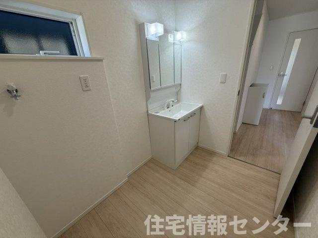 クレイドルガーデン下松市桜町　第1の独立洗面台|三面鏡裏収納を備えた使い勝手の良い洗面化粧台。小窓から自然光が入る明るい空間です。脱衣スペースもゆとりがあり、スムーズな家事動線をサポートします。