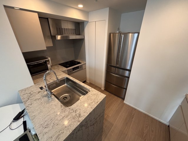 高級感あふれる天然石天板仕様のL字型対面カウンターキッチン。食洗機やディスポーザーを標準装備し、作業効率と機能性に優れています。リビングを見渡しながら快適にお料理が楽しめる上質な空間です。