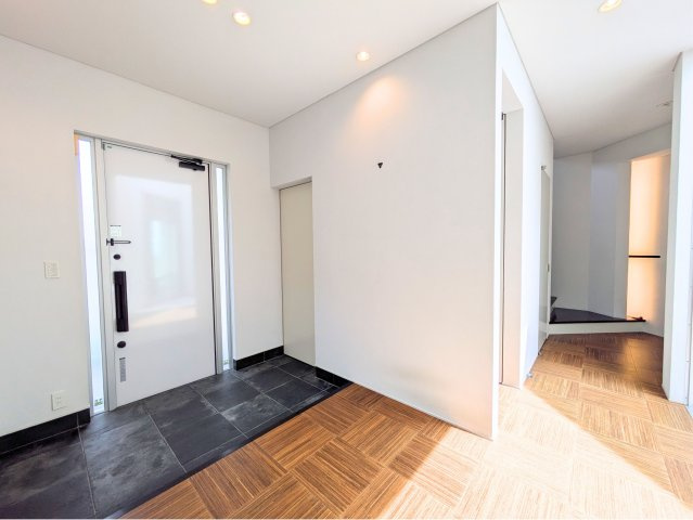 白水台6丁目戸建の玄関|清潔感のある白い扉とシックな土間タイルがお迎えします。間接照明がおしゃれな印象を与える玄関。