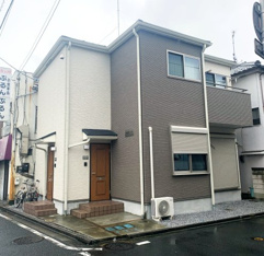 ツートンカラーの外観　暖かみのある木製ドア