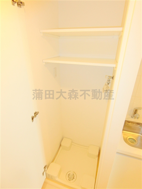 メイクスデザイン蒲田ウエストの設備|扉と棚付きの洗濯機置き場
