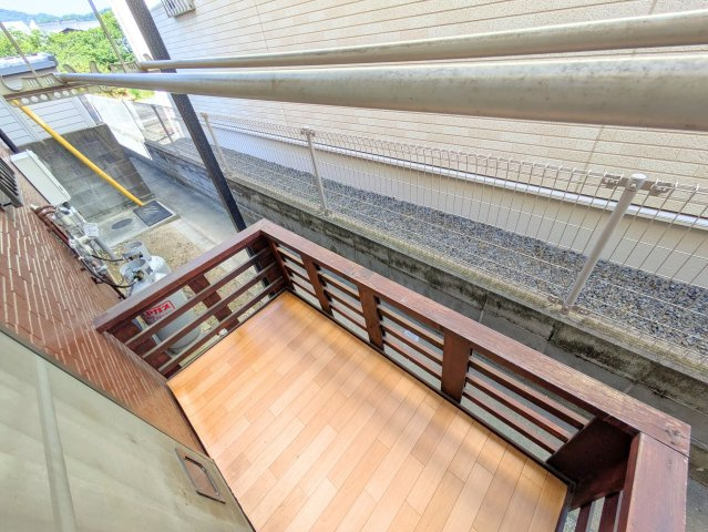 水泥町戸建のバルコニー|ウッドテイストの小さなスペースは、洗濯物を干す際やちょっとした作業に便利です。