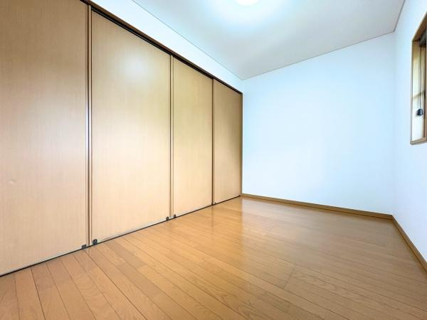 三芳　中古の洋室|明るいフローリングが印象的な洋室です。壁面には大容量の収納スペースを備えています。シンプルな設計で家具の配置もしやすいお部屋です。落ち着いた木目調が空間に統一感を与えています。