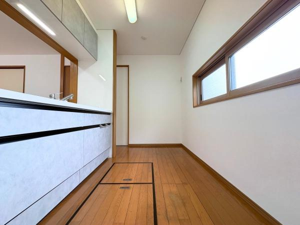 三芳　中古のキッチン|シンプルなデザインのキッチン空間です。窓から自然光が差し込み明るい印象です。木目調の床が室内に温かみを加えています。収納スペースも確保されています。