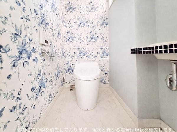 京が丘南3丁目　中古のトイレ|爽やかな花柄の壁紙が印象的なトイレです。床は明るいカラーでお手入れもしやすそうです。ワイドな空間設計がゆとりを感じさせます。シンプルな中にもこだわりを感じる一室です。