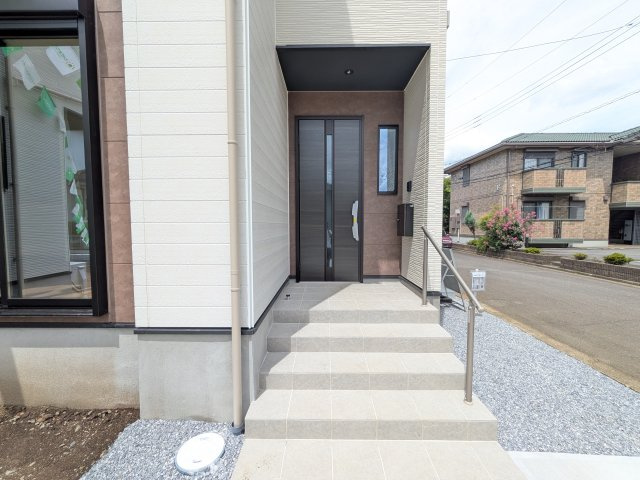 つくば市東光台　2期　新築戸建て　2号棟の玄関|お洒落な玄関ドアと洗練された外壁デザイン。家の顔にふさわしい上質な佇まいで、ご家族やお客様を迎えます。