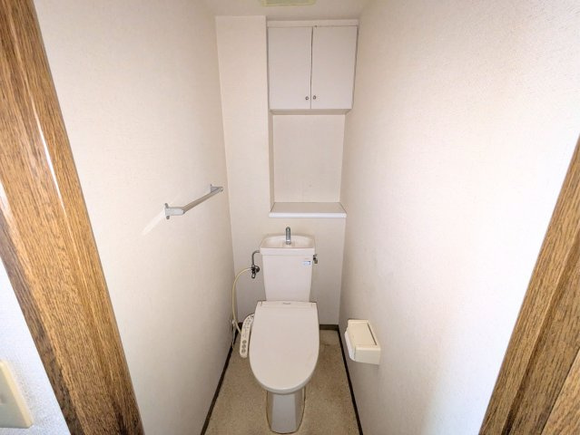サーパス三津弐番館のトイレ|上部に棚を備えた快適なトイレ空間。トイレットペーパーや清掃用品をすっきりと隠して保管できます。