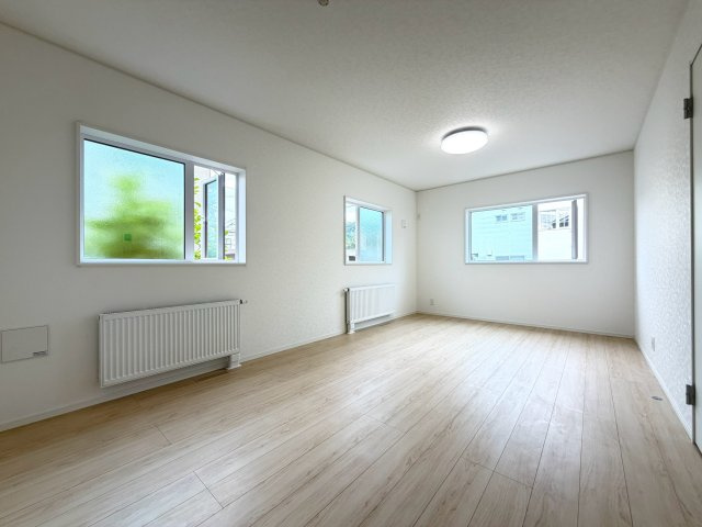 【新築戸建】札幌市南区川沿13条1丁目2棟の居間・リビング|リビングが見渡せる対面キッチンを採用。内装(壁・床・建具)は白を基調とし、明るい雰囲気となっています。(1号棟)