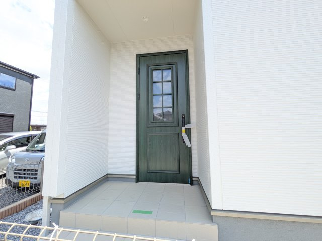 第1下妻市下妻丁　新築戸建　2号棟の玄関|お洒落な玄関ドアと洗練された外壁デザイン。家の顔にふさわしい上質な佇まいで、ご家族やお客様を迎えます。