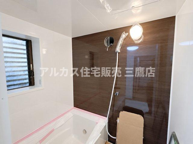 京王線 つつじヶ丘駅 8分 中古戸建 調布市西つつじケ丘1丁目の浴室|木目調壁面と清潔なホワイトが映えるシステムバス。シャワーヘッドやライトなど洗練された仕様になっています。