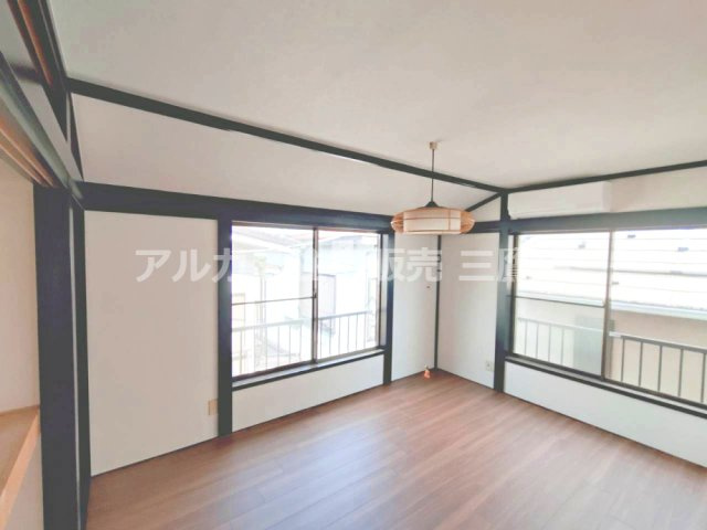 京王線 つつじヶ丘駅 8分 中古戸建 調布市西つつじケ丘1丁目の洋室|2面に大きな窓を備えた居室。濃色の柱や梁が空間を引き締め、木目の床と調和しています。