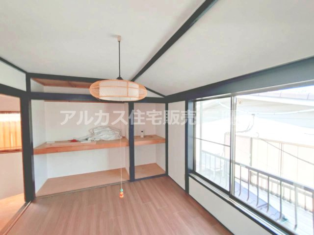 京王線 つつじヶ丘駅 8分 中古戸建 調布市西つつじケ丘1丁目の洋室| 壁一面に収納スペースを備えた居室。大きな窓と木目の床が、すっきりとした空間を演出します。