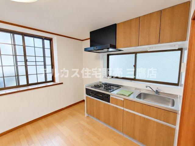 京王線 つつじヶ丘駅 8分 中古戸建 調布市西つつじケ丘1丁目のキッチン|明るく清潔感のある壁付けキッチン。正面や側面に窓があり換気・採光も良好で、吊戸棚などの収納スペースも充実しています。