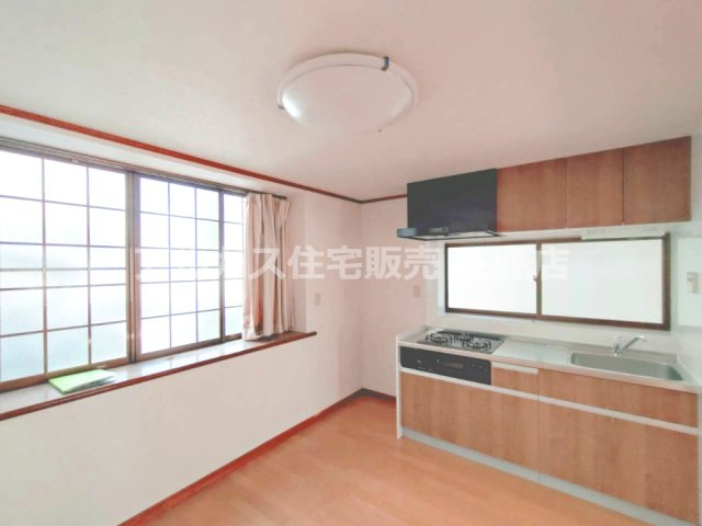 京王線 つつじヶ丘駅 8分 中古戸建 調布市西つつじケ丘1丁目の居間・リビング|木目調の扉が温かみを添えるキッチン。窓のある壁付けタイプで、作業スペースも確保されています。