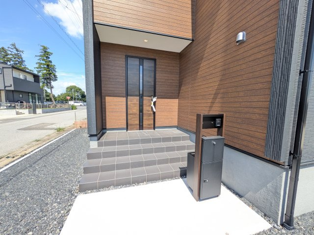 第1常総市坂手町　新築戸建　1号棟の玄関|お洒落な玄関ドアと洗練された外壁デザイン。家の顔にふさわしい上質な佇まいで、ご家族やお客様を迎えます。