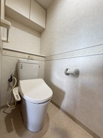 サーパス鷹子第三のトイレ|温水洗浄便座完備のトイレは、吊戸棚に予備の備品をしまえます。