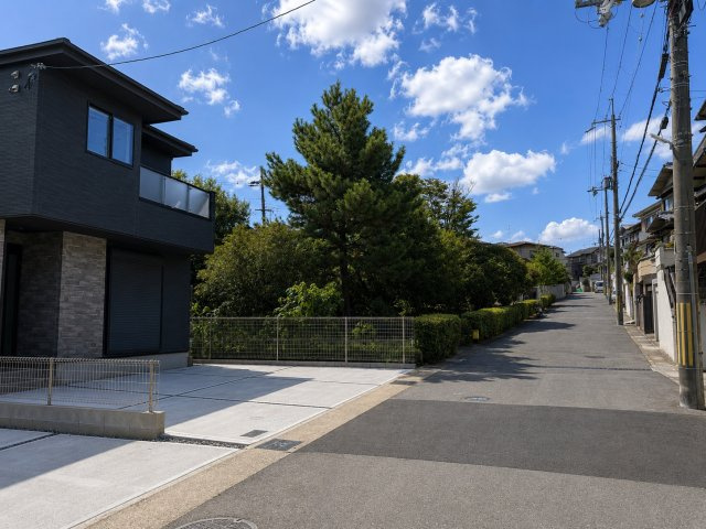 新築戸建 宇治市宇治大谷　即入居可能です！の前面道路含む現地写真|豊かな緑と青空が広がる、開放感あふれる住環境。ゆとりある前面道路で、車の出入りもスムーズです