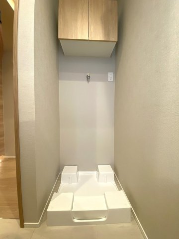 ストーク両国秀山のランドリースペース|洗濯機置場の上部や周辺には洗剤等を置ける便利なスペースがあり、日々の洗濯作業をスムーズに行えます。清潔感のあるデザインで日常の家事を気持ちよくサポートします。
