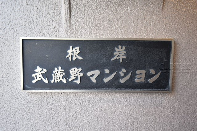 【現況写真】 | 根岸武蔵野マンション | エントランスに掲げられた、マンション名を示す館銘板。さほど激しく主張はしませんが、しっかりと掲示されています。～即日のご見学可能～　お問合せはお気軽にどうぞ。