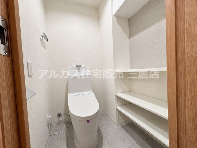 ライオンズヒルズ調布つつじヶ丘弐番館のトイレ|サイドに使い勝手の良い収納棚を備えた、清潔感のあるトイレ。
