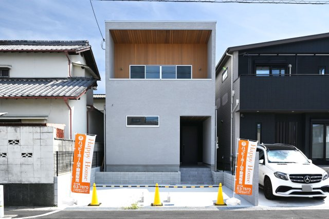 尼崎市南武庫之荘4丁目新築一戸建て│1LDK+2S+並列駐車2台可の外観|やわらかなグレーと木目のコントラストが目を惹く外観。深く設けたバルコニーが建物に陰影と奥行きを生み、シンプルになりすぎないデザインに仕上げました。細部にもこだわりが感じられる、街並みに映える一邸です。