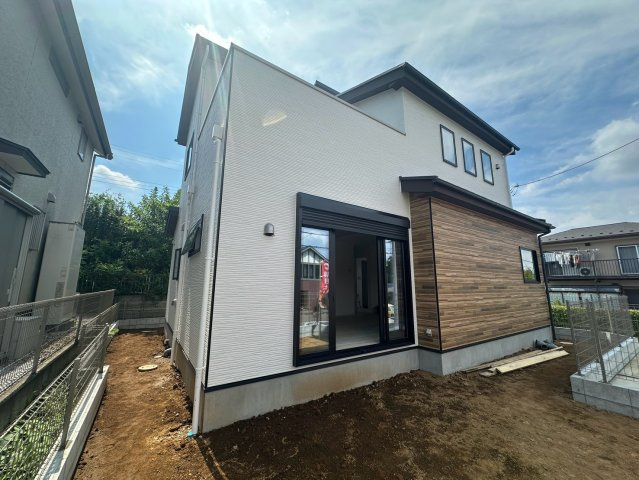 八王子市片倉町25期 新築戸建ての外観|お庭とリビングを繋ぐ大きな窓が特徴的で、室内とお外の空間が一体となったような開放感が味わえます！天気の良い日には窓を開け放ち、リビングからすぐにお庭へ出てお子様と一緒に太陽の下で元気に遊べます♪