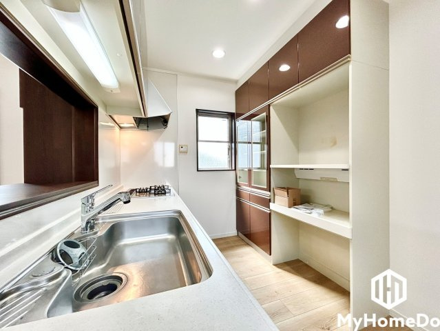 北区龍ノ口町３丁目のキッチン|背面にはキッチン本体と同デザインの大型カップボードが設置されており、食器類から電子レンジや炊飯器などの調理家電までまとめてすっきり収納できます。