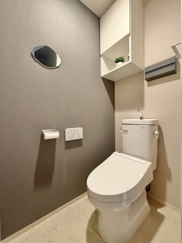 ノブレス浜松早出のトイレ|トイレはシックな色使いで落ち着く空間となっております。収納棚や飾り棚もあるのでシンプルに彩ることもできますね。