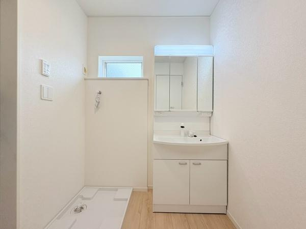 藤沢市城南２丁目の新築一戸建の独立洗面台|明るくシンプルなデザインが特徴の洗面台・洗面所です。使いやすい三面鏡と収納スペースが備わっています。室内は清潔感を感じられる白を基調とした内装です。床の木目調がアクセントになっています。
