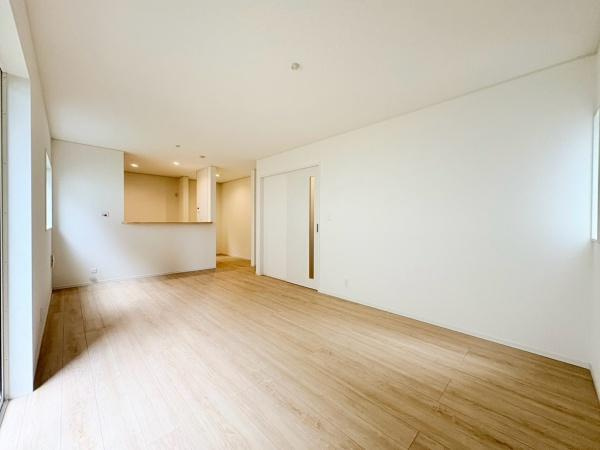藤沢市城南２丁目の新築一戸建の居間・リビング|開放感のあるリビングはシンプルなデザインが魅力です。大きな窓から自然光がたっぷり入り明るい空間を実現しています。床材のナチュラルな色合いが心地よさを演出します。仕切りのない間取りで広々とした印象です。